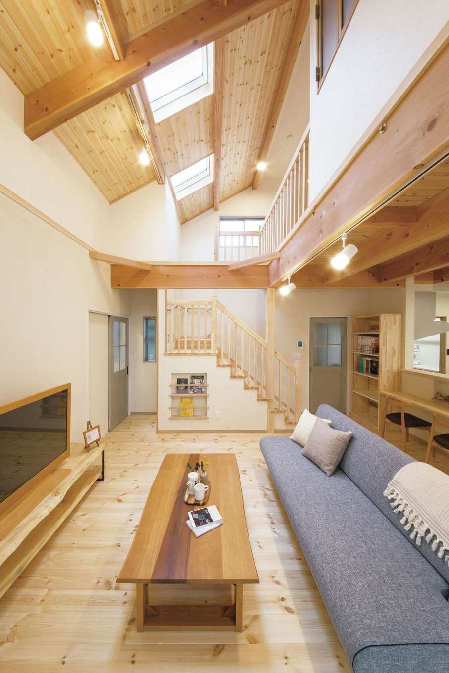 住まいるコーポレーション【デザイン住宅、収納力、自然素材】大きな吹抜けが1階と2階を繋ぎ、天井にはトップライトを設けて明るさを確保。階段下のマガジンラックには、新聞や子どもの絵本など収納でき、オシャレな雑誌を飾れば部屋のアクセントに