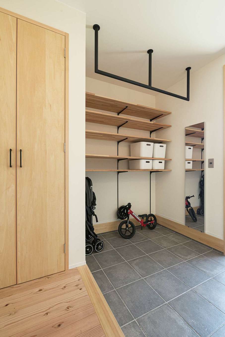 仲田工務店【趣味、自然素材、間取り】木の香が漂う玄関は土間仕上げのワンルーム空間に。多目的に使えるアイアンバーはご主人が懸垂できる仕様に特注で仕上げたのだとか
