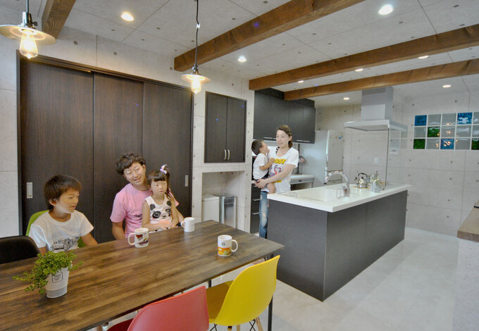 回遊性のあるアイランドキッチンは家族みんながお手伝いしたくなる。木のダイニングテーブルはご主人の手づくり 