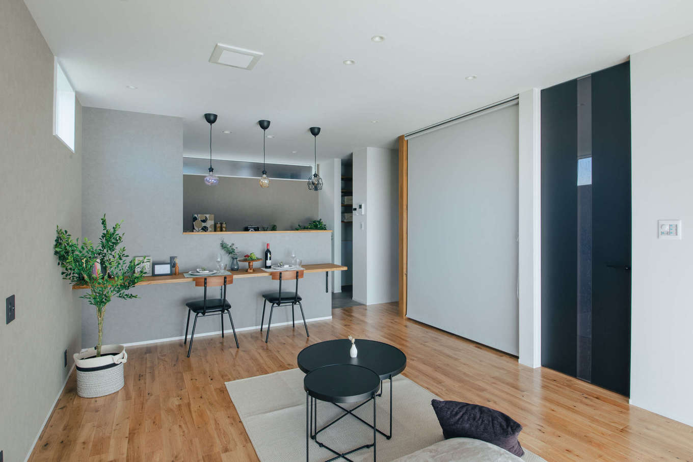 DAITOKU（大得工務店）【デザイン住宅、子育て、間取り】リビングを広く見せるハイドアを採用。隣接する畳コーナーはロールスクリーンで間仕切りも簡単だ