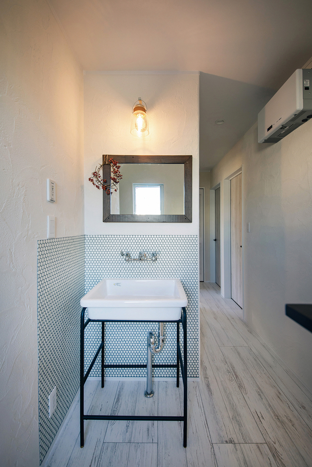2階ホールの洗面スペース。壁に取り付けられた独立型の鏡とシンクがスタイリッシュ
