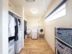 明るい日差しが差し込むランドリールーム。洗濯機と乾燥機が並び、収納スペースも充実しているため、家事効率が向上する設計。