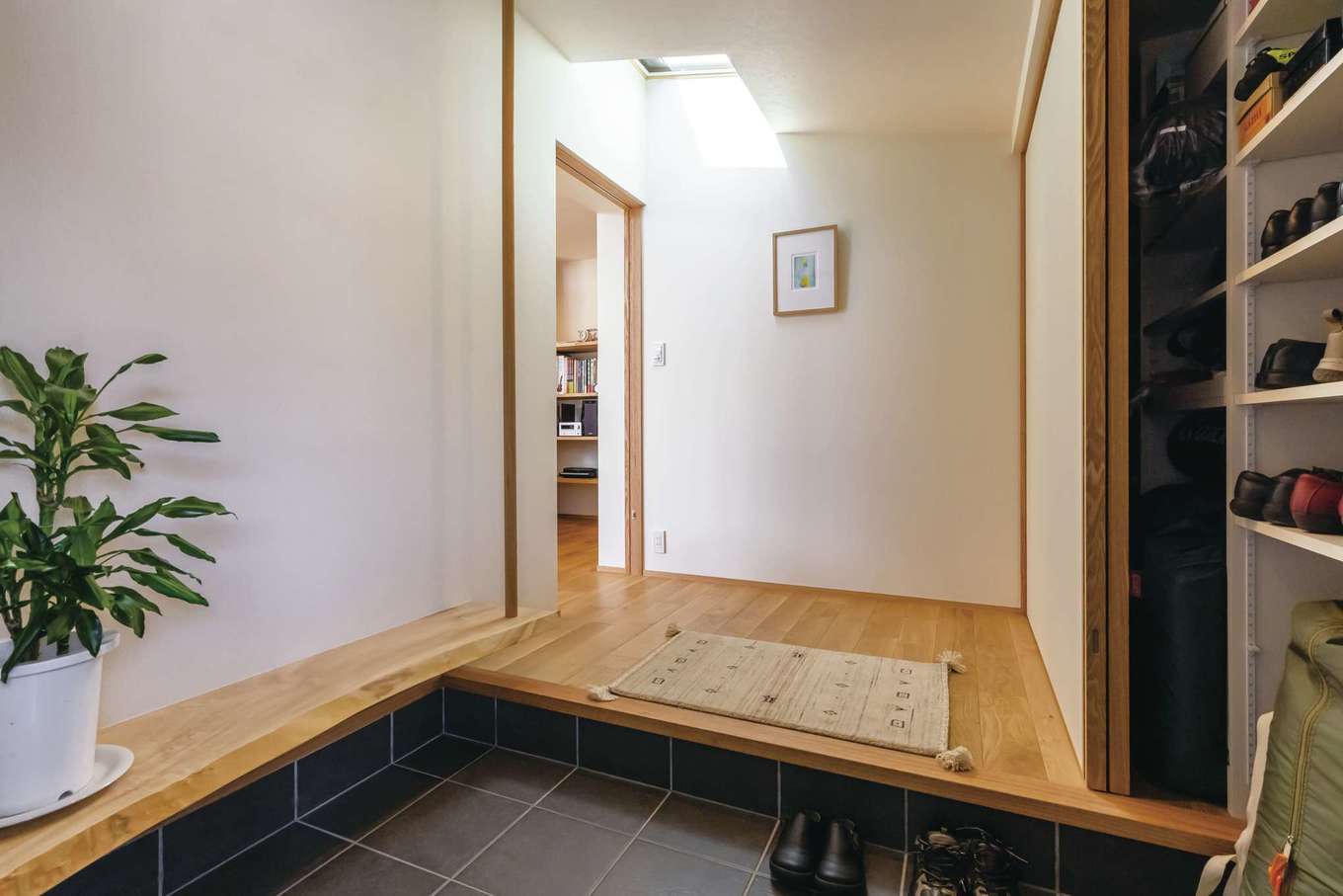 神谷綜合建設 カミヤの家【デザイン住宅、収納力、平屋】天窓から光が差し込む玄関ホール。壁一面に収納を設け　靴やBBQグッズなどを収納