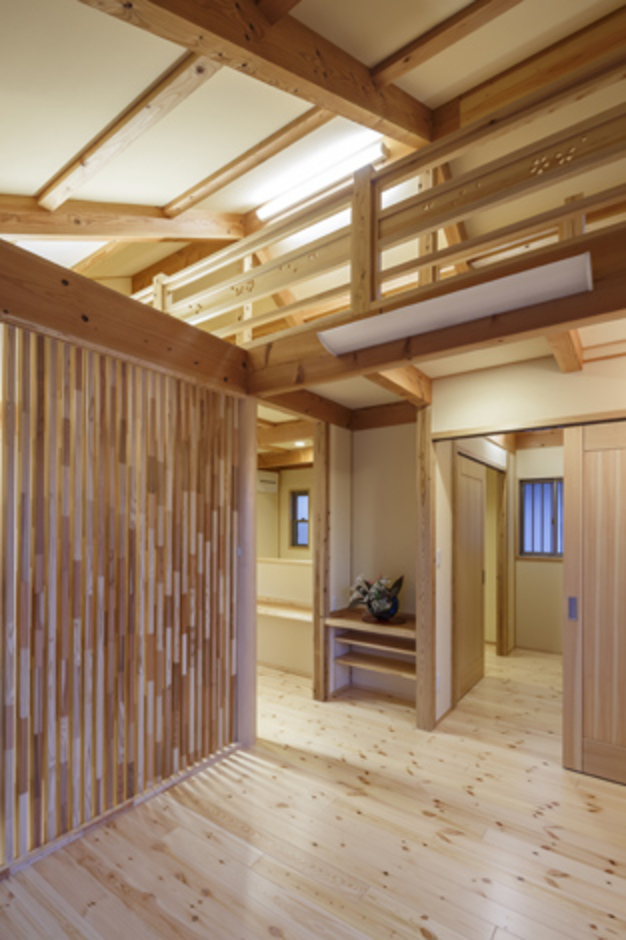 主寝室側からロフトをのぞむ。格子は目隠しと同時にインテリアの一部にもなっている。中央の棚には仏壇を配置する予定