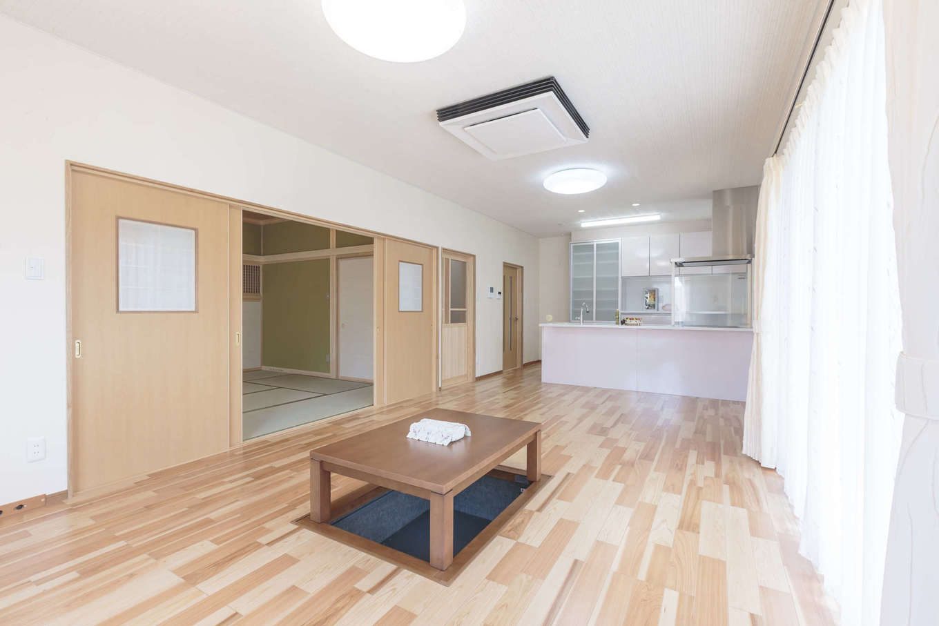 まちの大工さん 鈴木工務店【夫婦で暮らす、間取り、平屋】広々としたLDKに掃出窓から明るい日差しが注ぐ。リビングには掘りごたつがあり、冬にはこたつで暖をとりながら愛犬と一緒にゆっくり寛げる