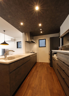 落ち着きのあるカラーでまとめたキッチンは、食器棚と扉の色を合わせることにより、統一感のある仕上がりに。足元には床暖房を設置しているので、冬でも暖かい