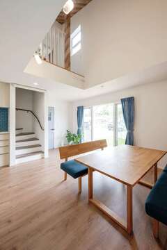 吹抜けと大開口へ視線が抜ける開放感あふれるリビング。「ただいま」を言ってから2階へ上がるようリビング階段を設けた