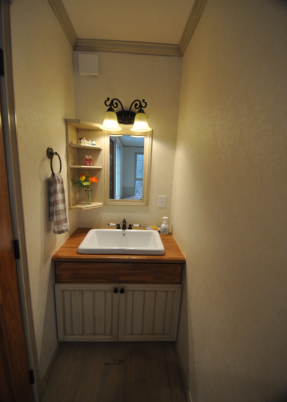 リンゾー【デザイン住宅、輸入住宅、インテリア】2階の洗面コーナー。収納扉にLDKの腰壁と同じ材料を使用。照明器具も1階の洗面コーナーと揃えた