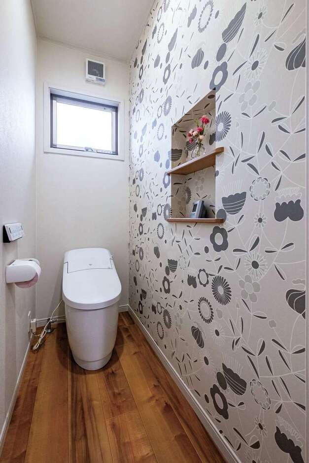 洗面脱衣室とお揃いの壁紙をアクセントに。小物や時計などを置けるニッチを付けた