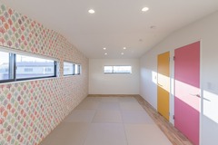 明るくカラフルな子ども部屋。壁紙のデザインが楽しげな雰囲気を醸し出し、遊び心をくすぐる。
