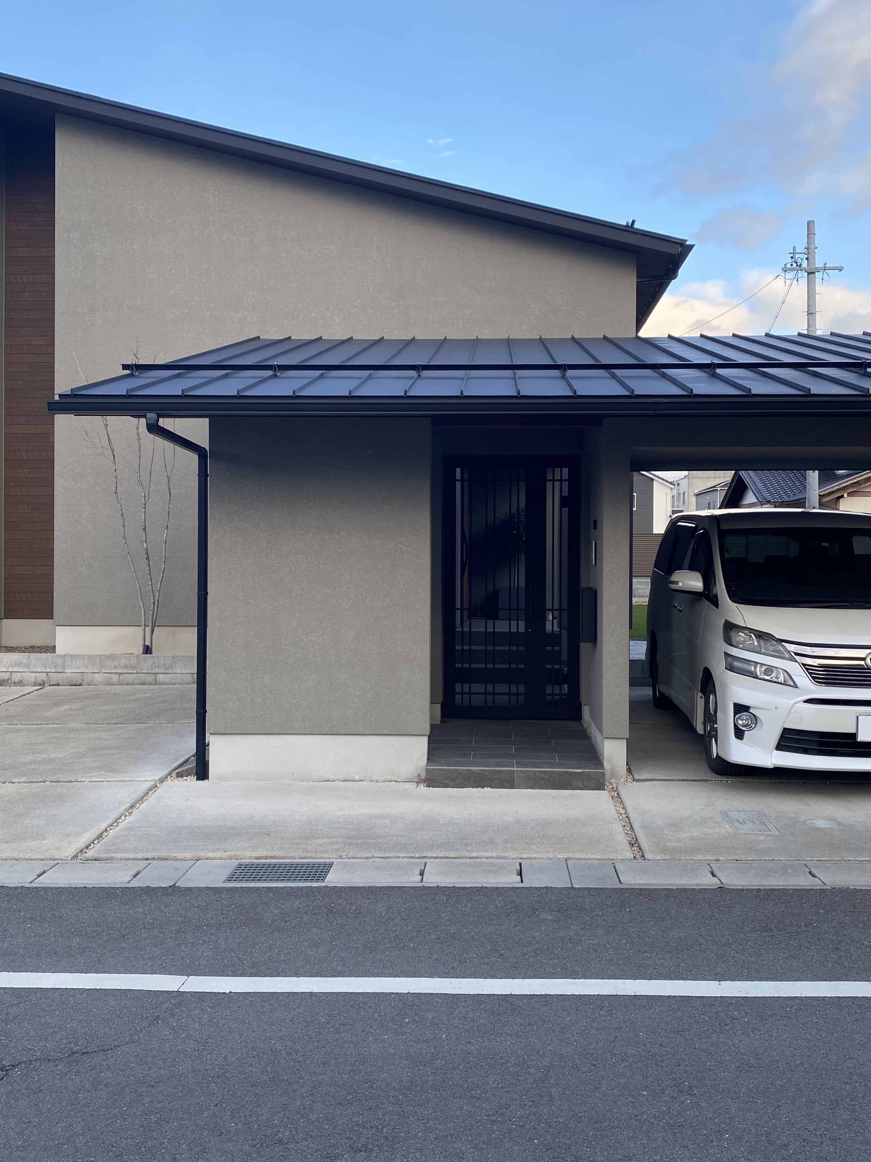 安田住宅｜安田建築設計室｜シンプルでモダンなデザインの平屋外観。門扉を備え、車２台分のインナーガレージを併設している。