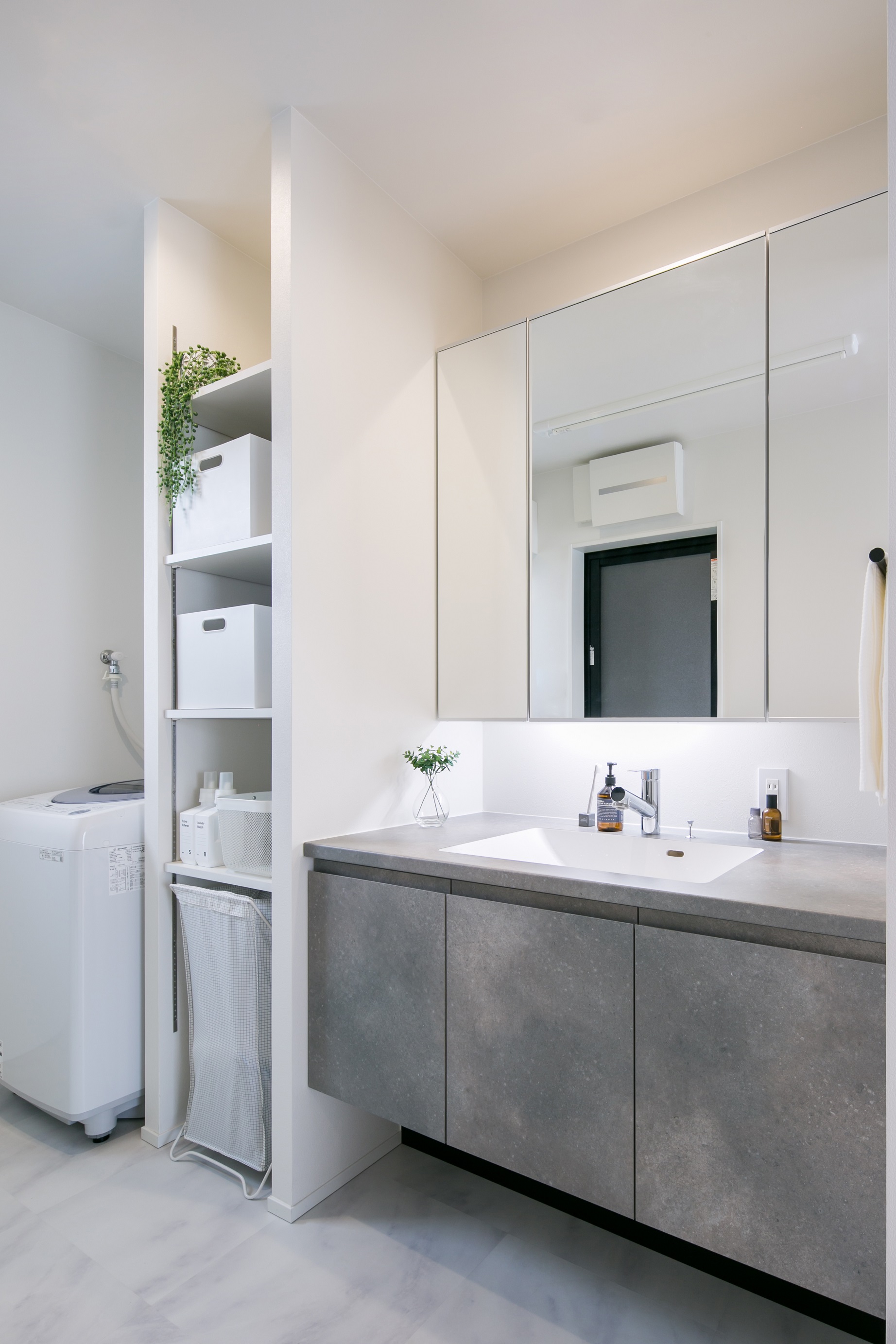 シンプル｜LDKからすぐに行ける洗面脱衣室には収納たっぷりの造作洗面。すぐ隣にはタオルなどを収納できる棚を設置。