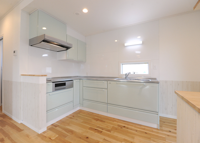 キッチンをL字型にすることで、リビングダイニングが広く使えるようになった。造作の作業台も便利