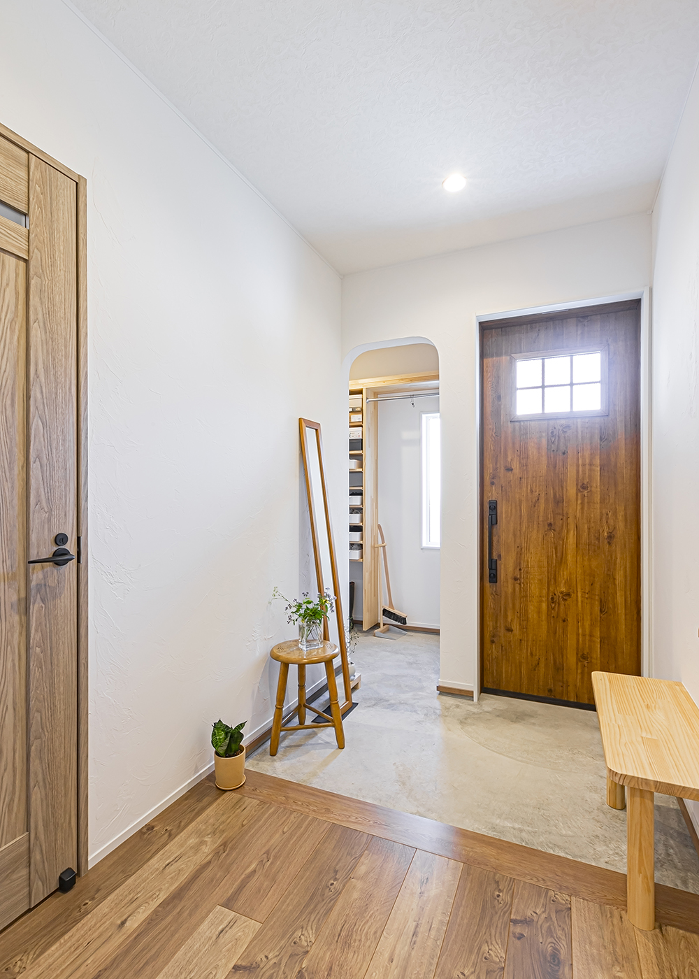 cozy house（小塚建設）【二世帯住宅、間取り、平屋】インテリアに馴染むよう玄関ドアは木目のものをチョイス。造作したアーチの垂れ壁がかわいいシューズクロークは来客からの視線が気にならない配置に