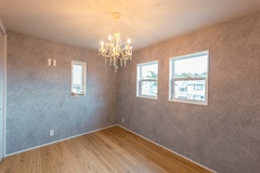 優雅なシャンデリアが印象的な居室。柔らかな光とグレーの壁が心地よい時間を生みます。
