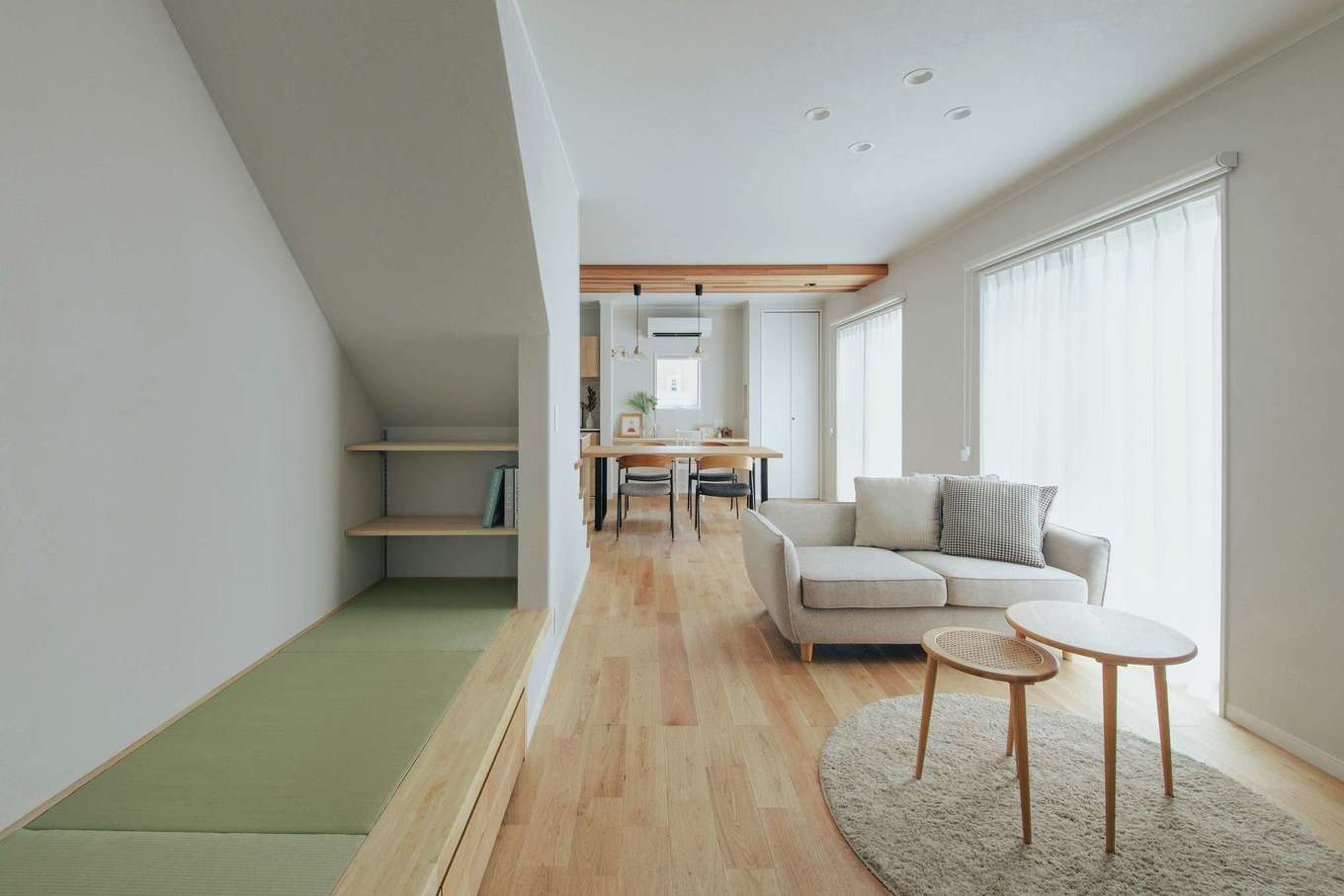 ほっと住まいる【自然素材、間取り、インテリア】玄関ホールのドアを開けるとリビングが広がる。大きな窓から差し込む自然光、そして奥に続くキッチンが開放感を感じさせるつくりに