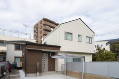 モダンなデザインの二階建て住宅の外観。シンプルで洗練された印象を与える外壁素材とカラーリングが調和している。