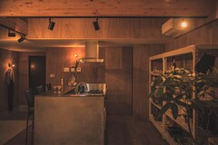 素材感にも こだわった。キッチンの腰壁はモルタル。カウンターはステンレス、業務用の収納棚を使用。