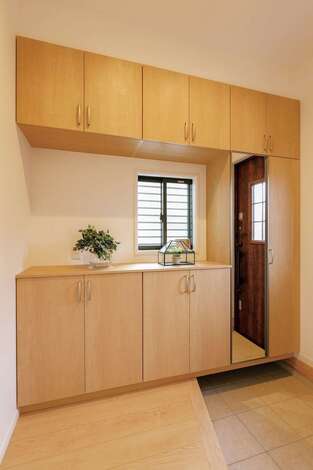 ゆったりとした広さを確保した玄関ホール。造り付けのシューズクロークが天井までぴったりと収まり、見た目も美しい仕上がりに。頭のてっぺんから足のつま先までチェックできる姿見もビルトイン