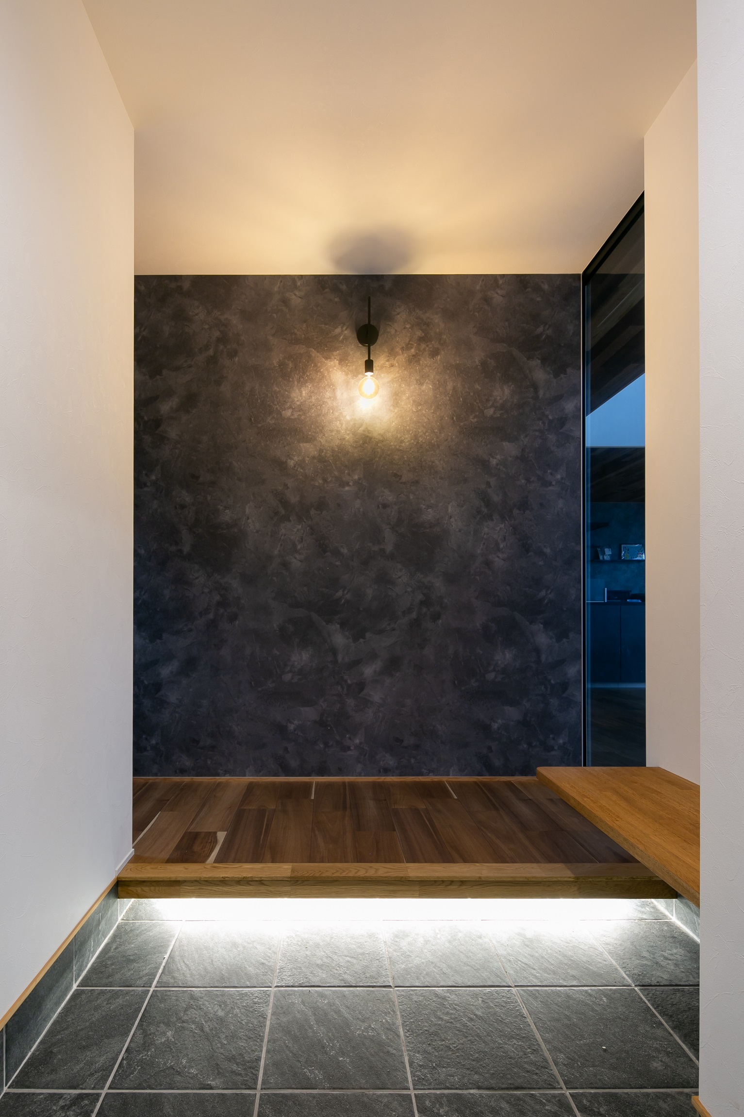 シンプル｜2.5帖の玄関ホール。
ブラケットライトと間接照明がお出迎え。