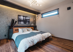 LDKと一転して、ブルックリンテイストでデザインしたホテルライクな主寝室。アクセントクロスに間接照明をあててニュアンスを出した。ここからも中庭にアクセスできる