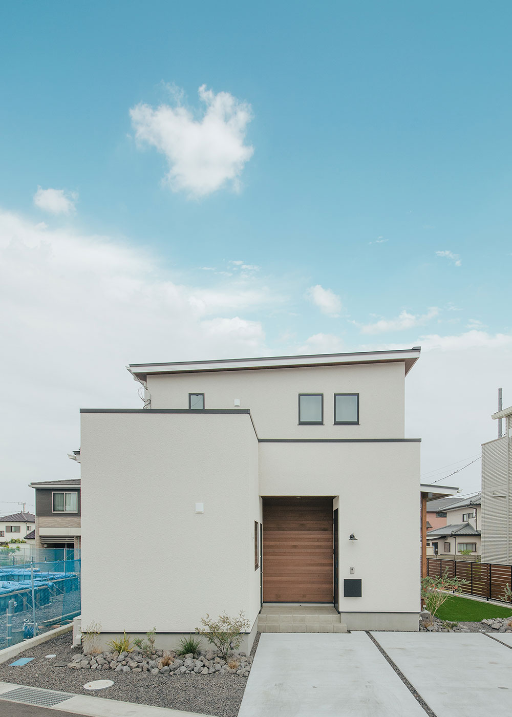 フジモクの家（富士木材）【デザイン住宅、子育て、自然素材】シンプルかつシャープなフォルムだが、玄関回りの無垢によって印象はやわらか。通り側は開口を減らし、内部の様子がもれないようにしている
