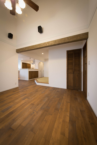 勾配天井が開放感を演出する2階のリビング。アンティーク風に仕上げた梁や垂れ壁、段差などにより、穏やかにゾーン分けがなされる。収納も随所に用意され、空間のスッキリに貢献