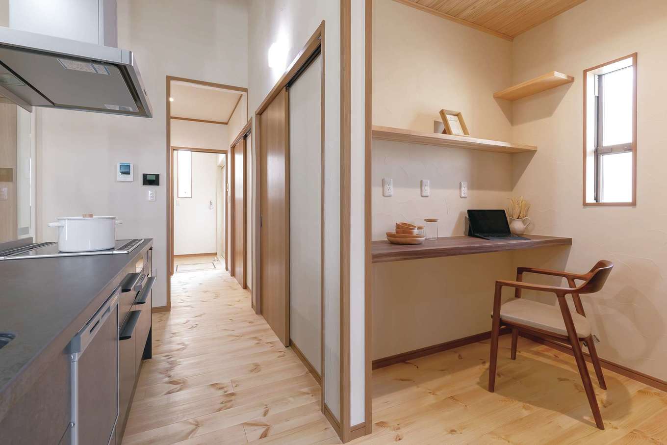 住まいるコーポレーション【デザイン住宅、自然素材、夫婦で暮らす】アイランドキッチンの背面に設けたパントリー。収納庫と作業カウンターに加え、冷蔵庫やオーブンレンジなどの家電を一か所にしまって生活感を隠すようにした