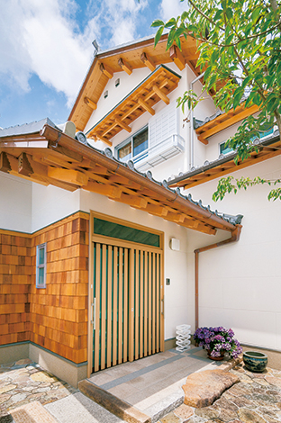 櫻 工務店【和風、自然素材、高級住宅】玄関の庇は、柱なしでスッキリ仕上げるため、二重垂木に。寺 社建築のような仕上がりから、大工仕事の確かさがうかがえ る。瓦は、地元の瓦屋さんに特注して焼いてもらった日本瓦