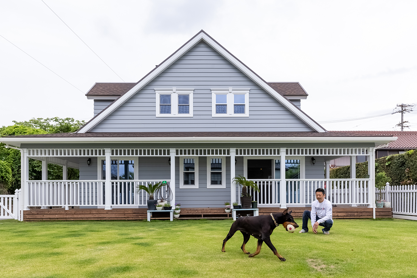 ジェネラルアメリカンホーム【輸入住宅、ペット、ガレージ】青々とした芝生のドッグランと、大きな屋根に覆われたカバードポーチが印象的なN邸の外観