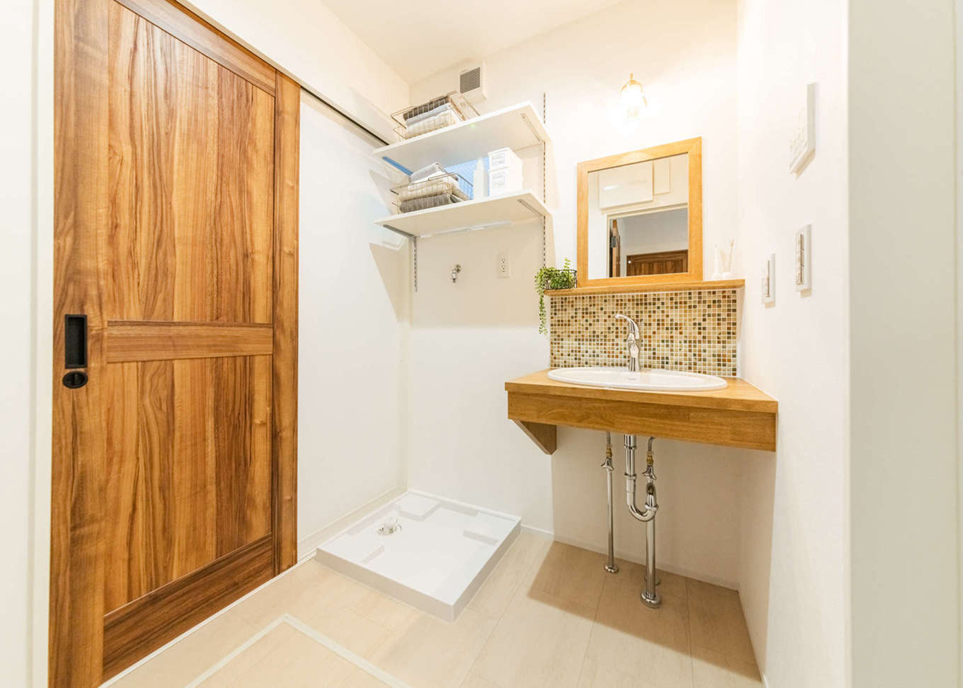 アーキテックス【1000万円台、デザイン住宅、収納力】玄関ホールから直結の洗面室。子どもたちが泥んこで帰ってきても、リビングが汚れる心配がない。デザインと機能性を両立させた洗面台は、デザイン照明、モザイクタイルの組み合わせが好評