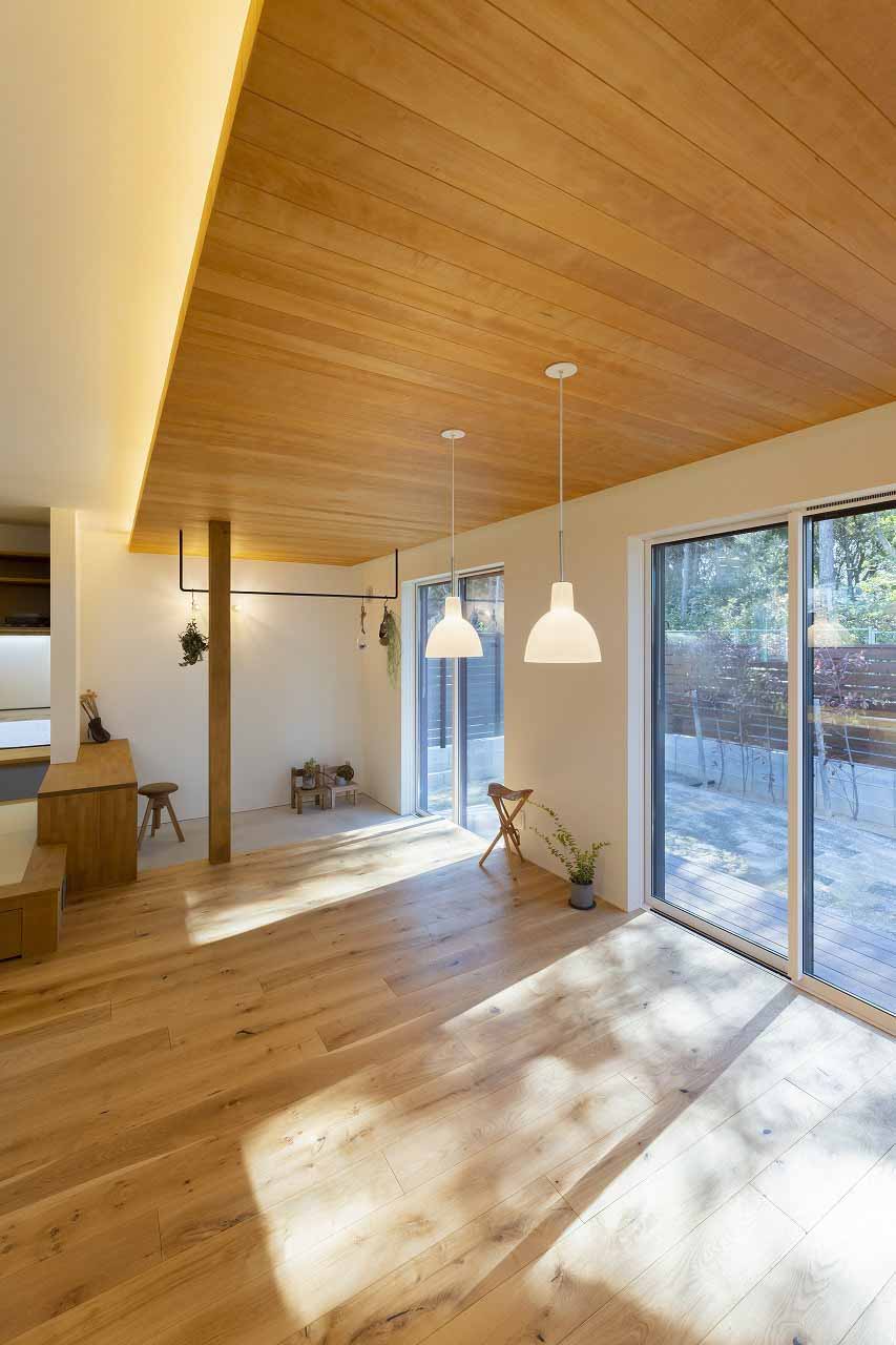 温戸ライフ【子育て、収納力、ペット】隣の植栽を借景にしたリビングダイニングで心地良く過ごせる。外にはウッドデッキが広がり開放感もたっぷり