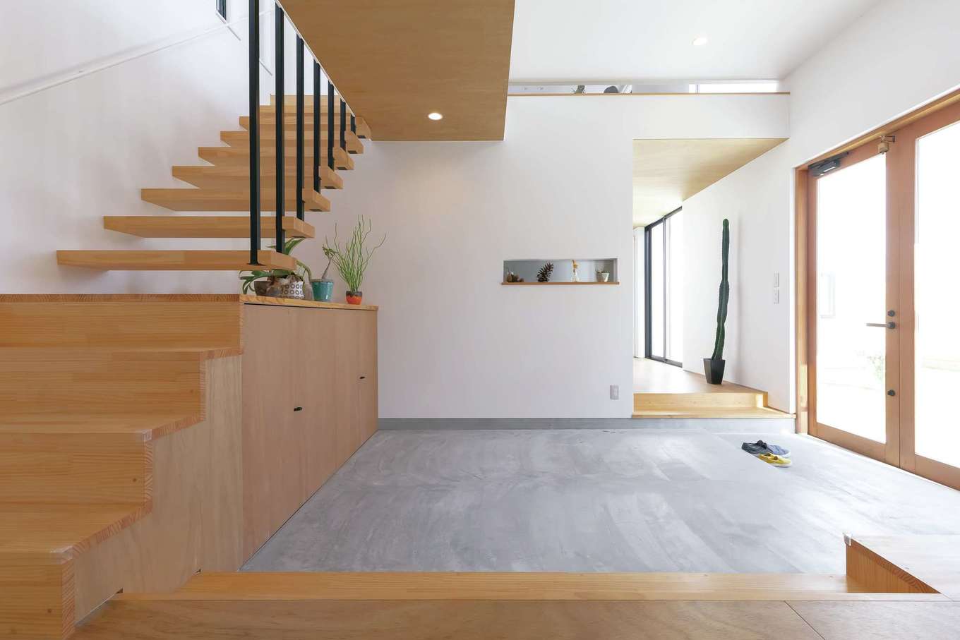 MABUCHI【デザイン住宅、建築家、インテリア】子どもの散髪をしたり、ご近所さんとおしゃべりしたり、多用途に使える10畳の土間。奥に主寝室、サニタリー、ウッドデッキを集約した