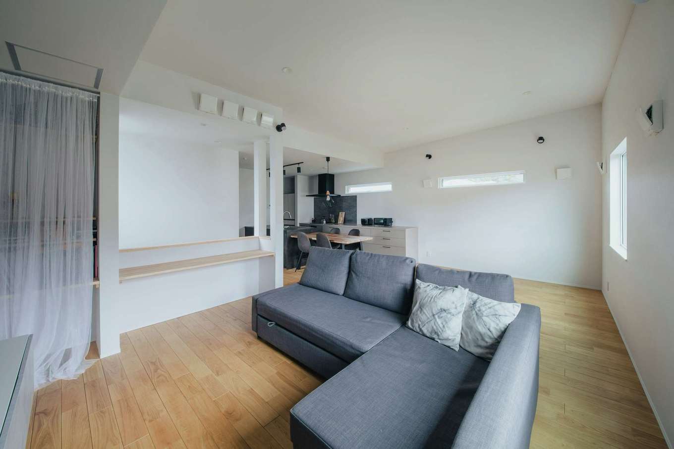 絆家（きずなや）【デザイン住宅、趣味、ガレージ】リビングは屋根の緩やかな勾配を利用した高天井に。大きな窓も設けて開放的な空間を実現。プライバシーを守りつつ、２階LDKならではの眺望も楽しめる