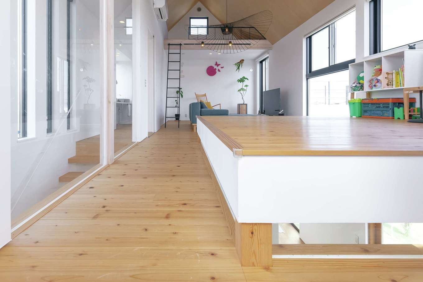 MABUCHI【デザイン住宅、建築家、インテリア】2階の中心に配置した小上がりのユーティリティ。寝そべると、ちょうど目線の先に緑の田園風景が広がり、心地よくてウトウトしてくる。床下の細い窓から1階の土間が見える