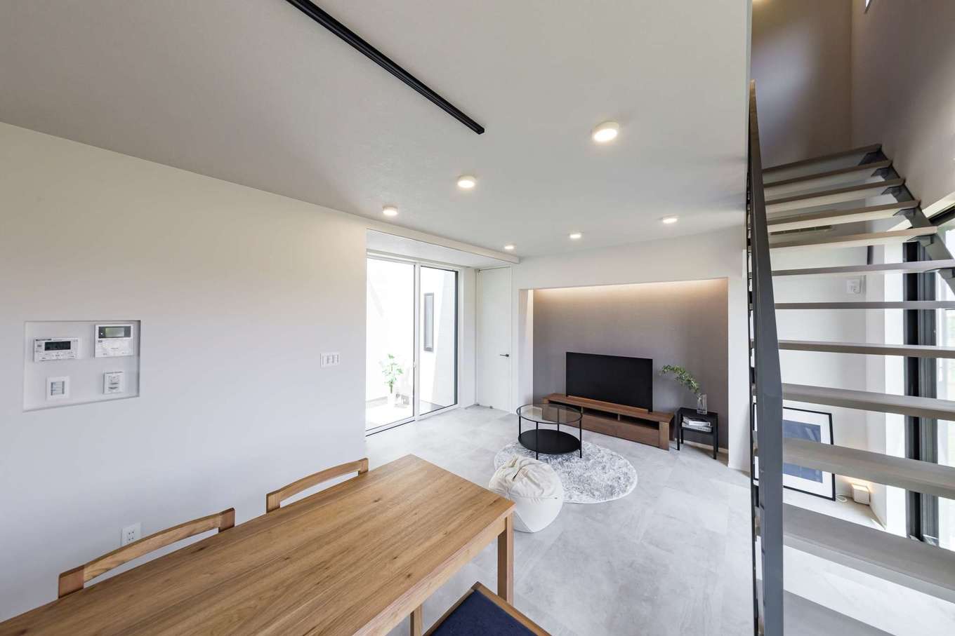 Gate air house/阿部住宅【デザイン住宅、間取り、インテリア】白・黒・グレーを基調としたシンプルで飽きのこないリビング。階段をスケルトンにすることで視線が抜けていき、圧迫感をなくした。地熱利用の換気システムでどの部屋の温度も均一に