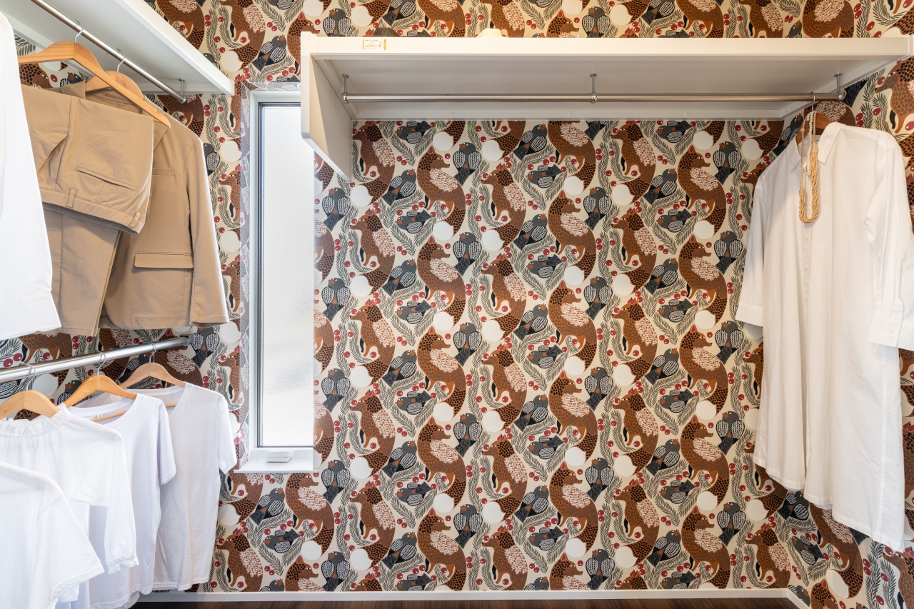 サンジョーホーム｜壁紙にマリメッコのデザインを取り入れたウォークインクローゼット。衣類を整理しやすいハンガーレールが豊富で、機能的かつスタイリッシュな空間である。
