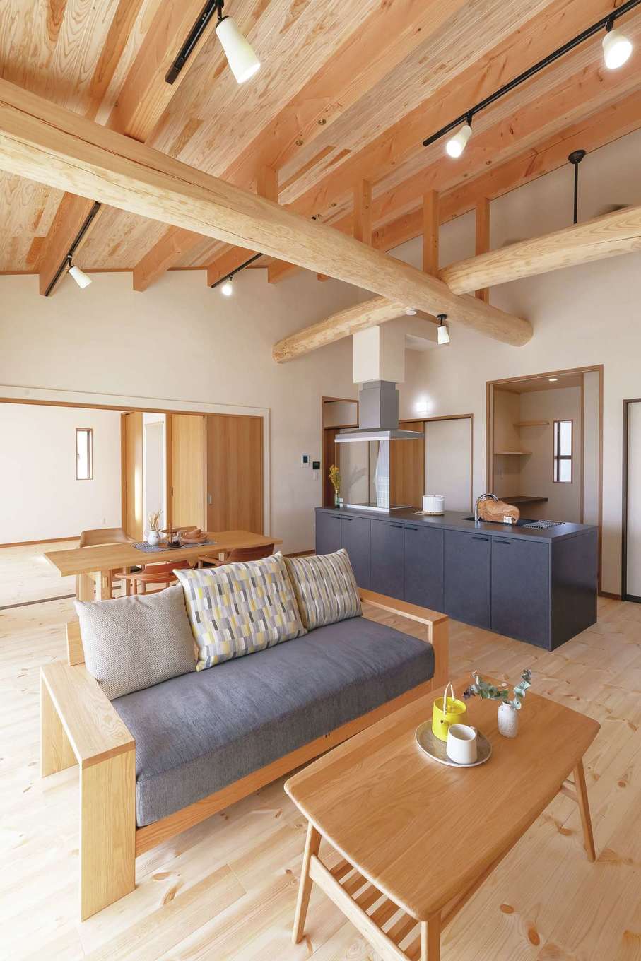 住まいるコーポレーション【デザイン住宅、自然素材、夫婦で暮らす】勾配天井が圧倒的な開放感をもたらすLDK。リビングの奥は寝室で、引き戸で仕切って利用できる。室内の床は厚さ30ミリのパイン材。珪藻土との相乗効果で、室内の湿度を年中適切にキープする