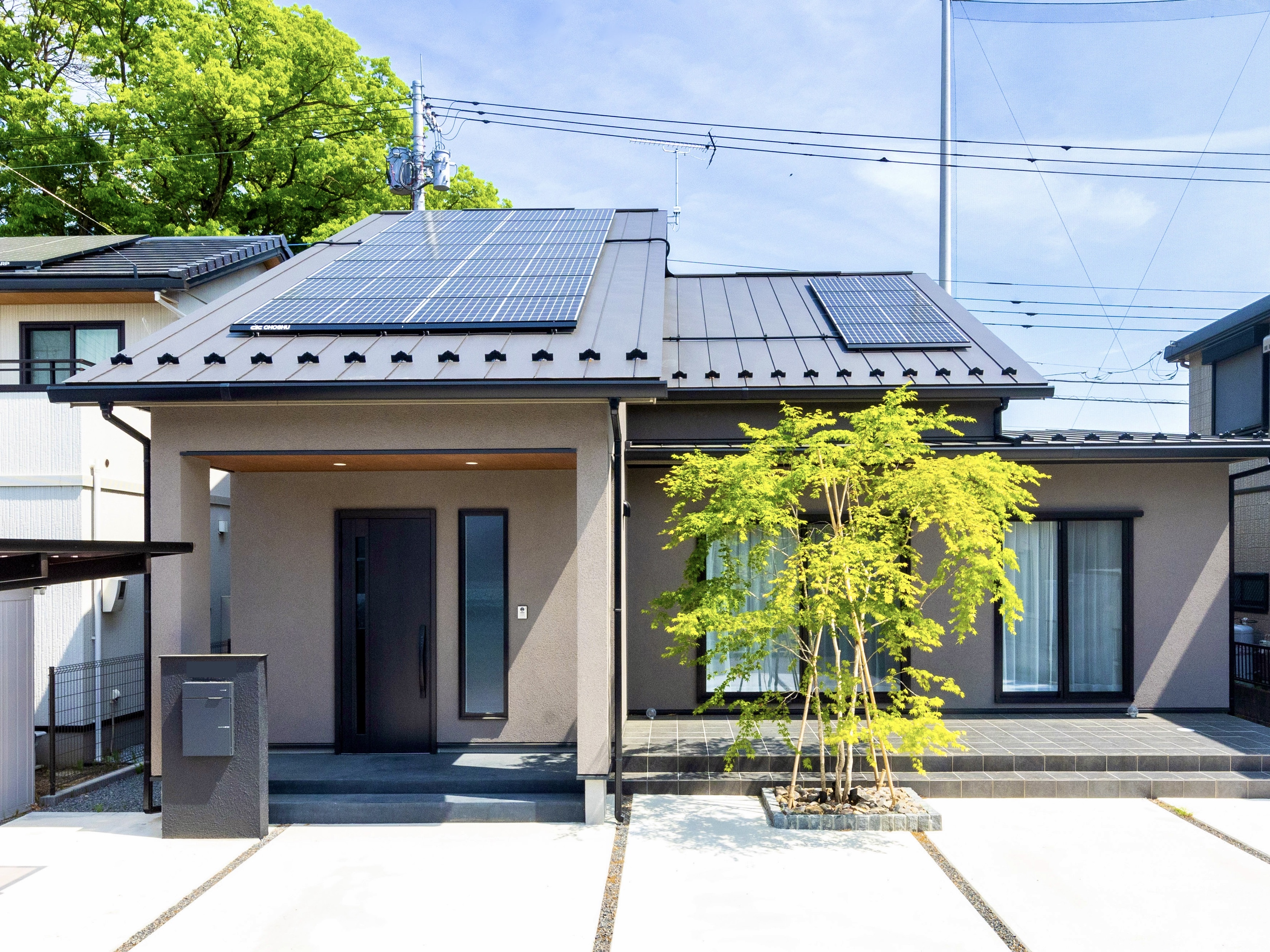 エスホーム｜落ち着いた色調の現代的な住まいの外観。太陽光パネルが屋根に設置され、環境にも配慮されたデザインである。