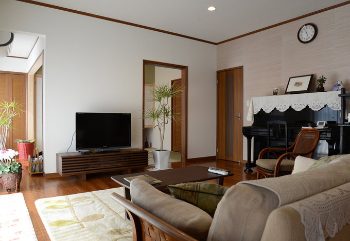 壁の一部を異なる色合いで貼り分けている。チークのフローリングは、深く暖かみのある色合い