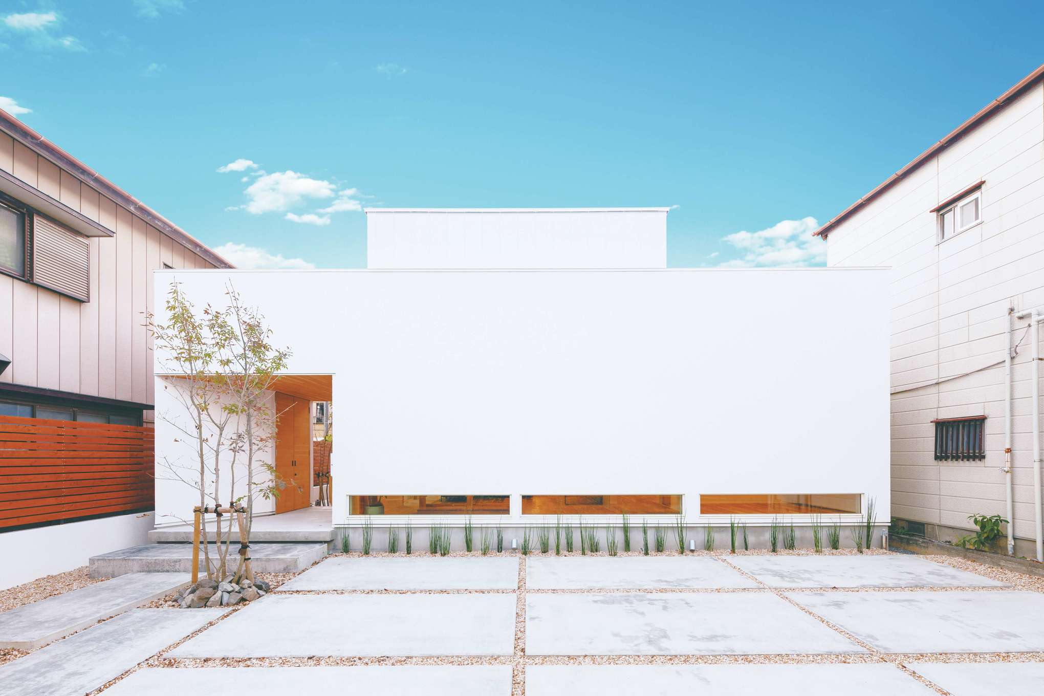 住家 JYUKA【デザイン住宅、間取り、建築家】開口部を極力減らした、シンプルを極めたファサード。ポーチを抜けた先はテラスへと続く