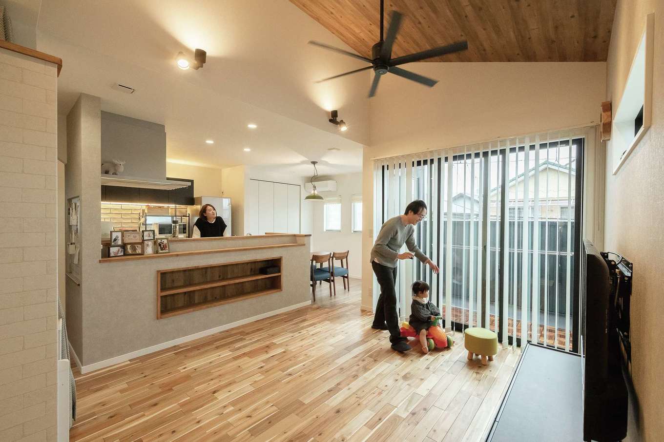 三和建設【デザイン住宅、子育て、間取り】2階のLDKは約20畳。隣の畑に将来家が建つ可能性があるので、南側に大きな窓を作らず、南東にバルコニーを設けて光を取り込むようにした。肌触りのいい床は無垢のアカシアで、冬でも素足で過ごしたくなる