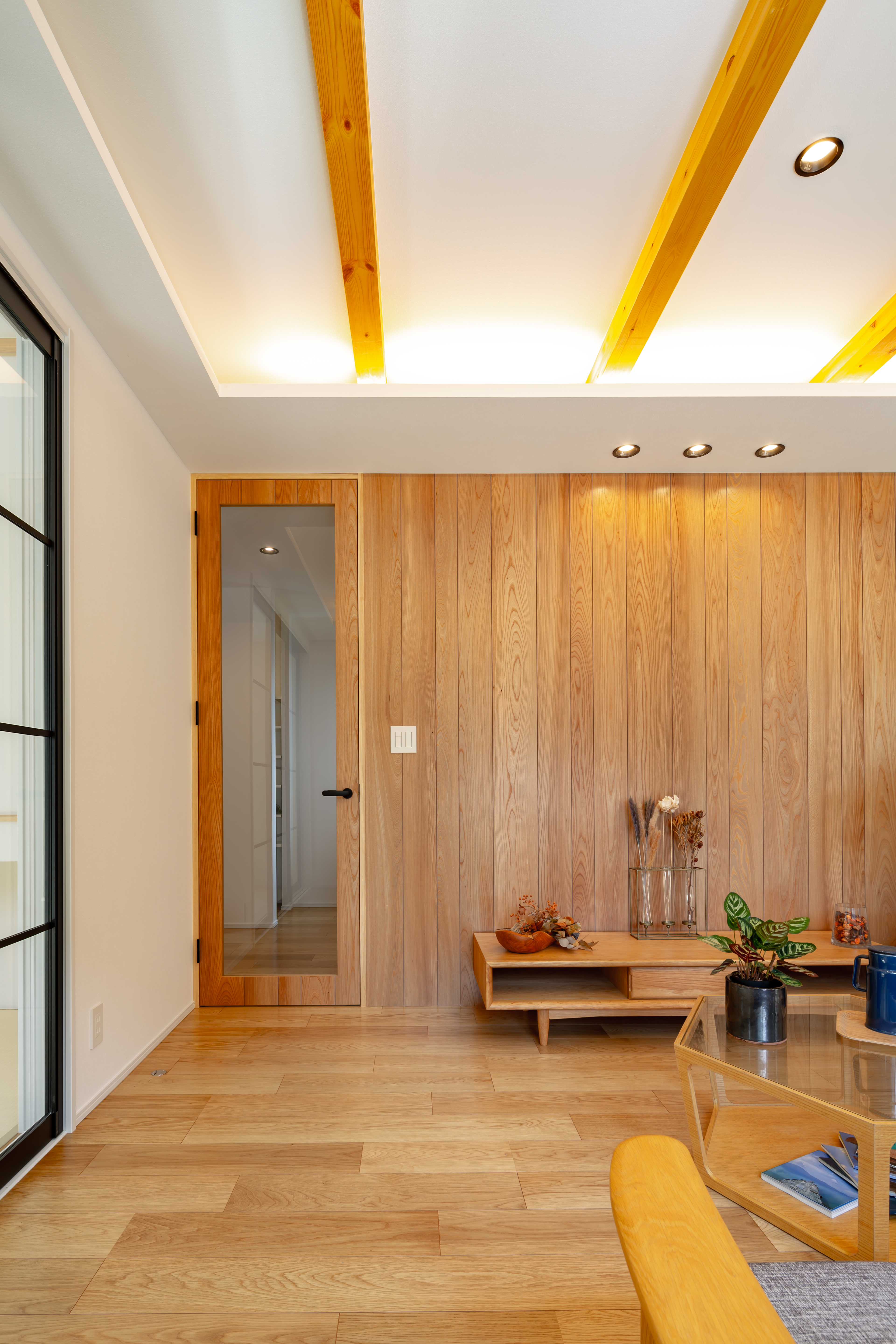 ムニカデザイン（まほろばホーム）｜深みのある木材を使うことで、落ち着いた高級感のあるリビングに。間接照明を組み合わせれば、陰影が美しく際立ち、温かみのある空間に仕上がり