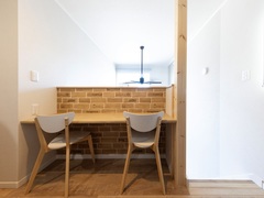 2階の廊下に設けたカウターは、レンガ調の壁がアクセントのスタディスペース。明るい色合いの家具と開放感ある窓からの光で、快適な学習環境を提供する。