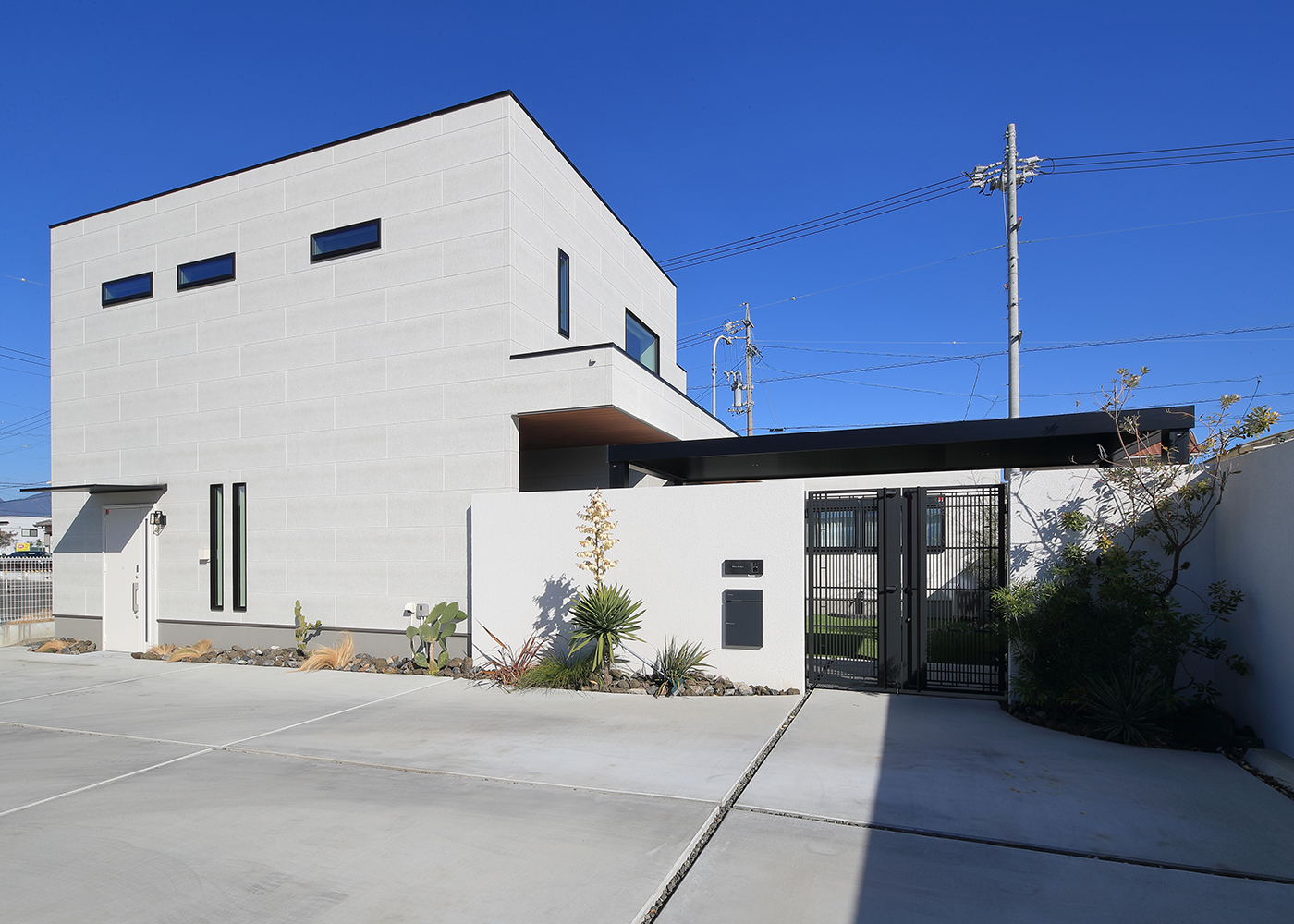 TOZAKI HOME 戸﨑建設　【デザイン住宅、間取り、インテリア】広々とした駐車スペースの奥に佇むS邸。シンプルでありながら細やかな色調の外壁が上品な美しさを醸し出す