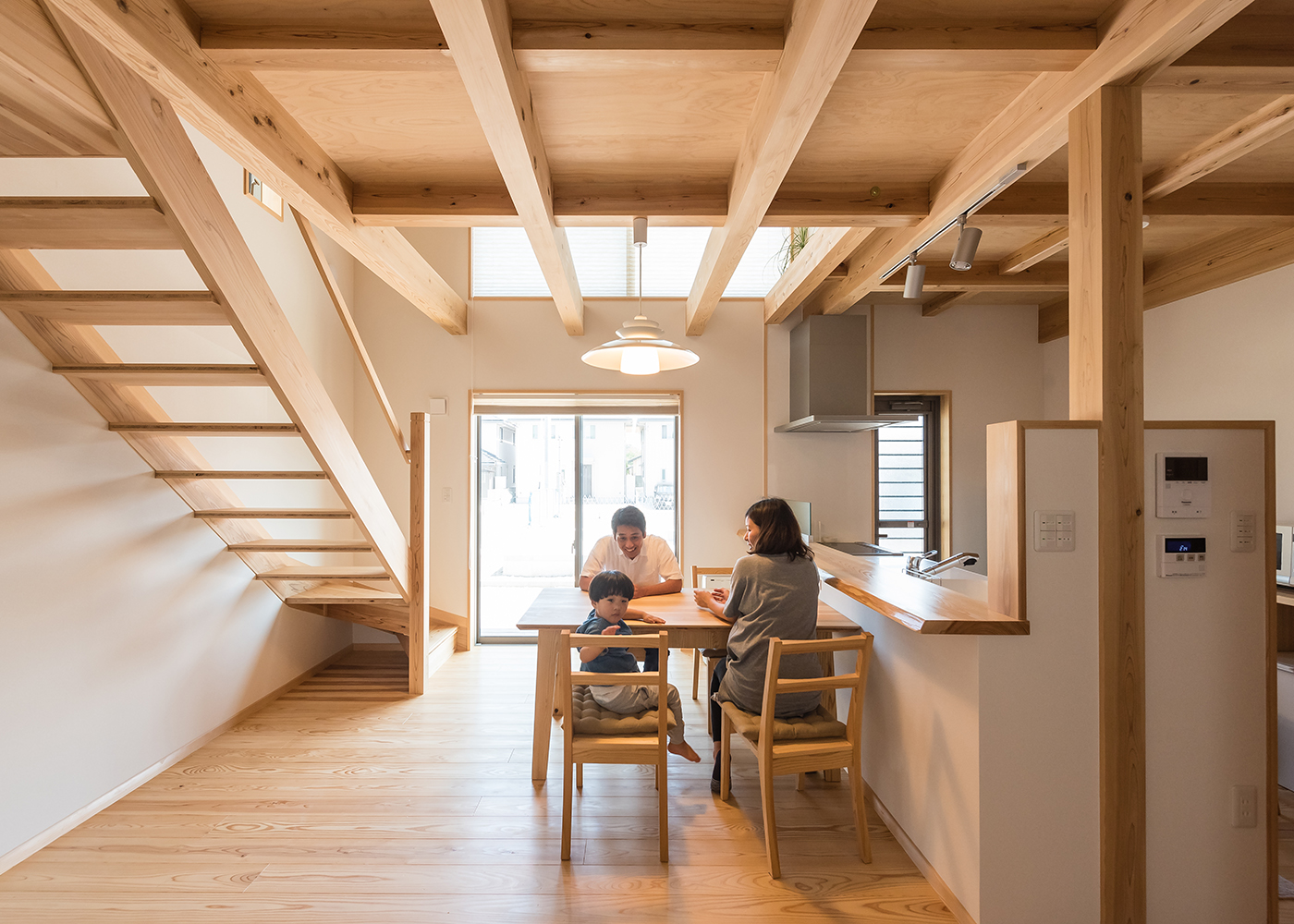 アクトホーム【収納力、自然素材、省エネ】LDK空間は吹き抜けで明るく、照明や窓の配置まで工夫した。家族みんなが自然と笑顔になるくつろぎ空間