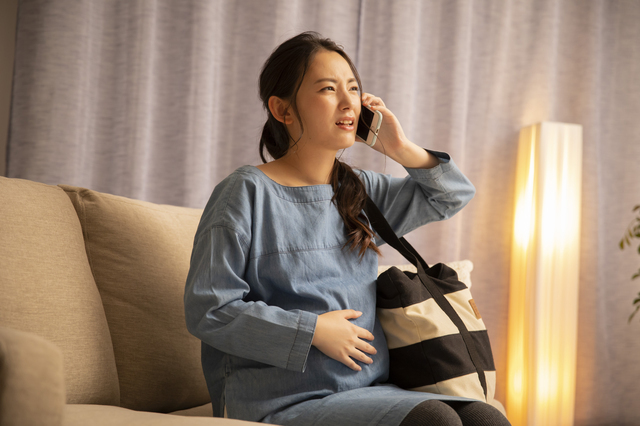 陣痛で電話する妊婦,陣痛タクシー,