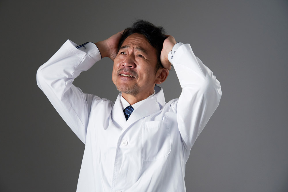 頭を抱える男性医師
