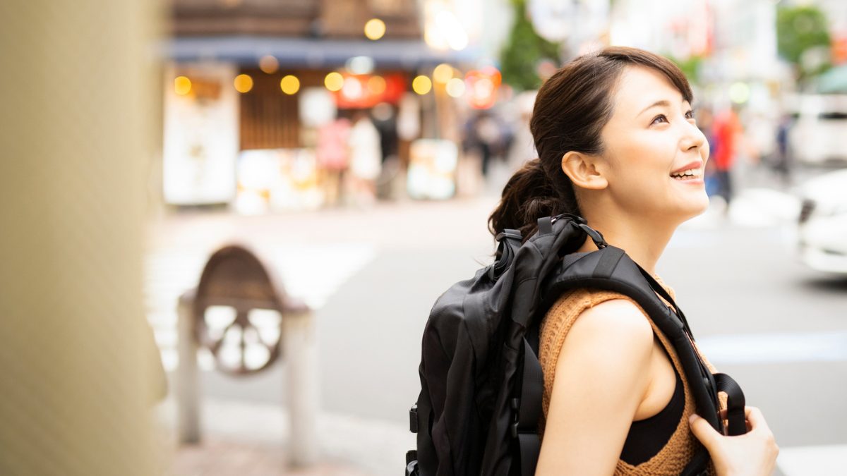 バックパックで街を歩く女性