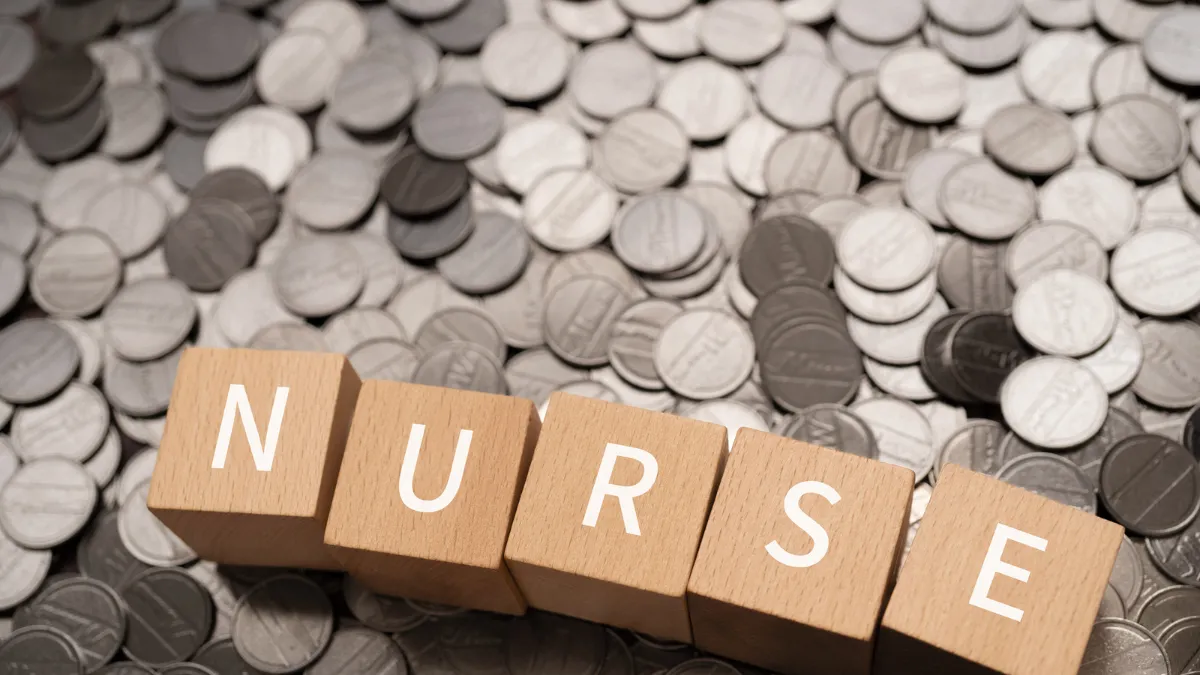 お金の上にnurseと書いてあるブロックが置いてある